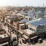 Solar panel rooftops spreading across a Pakistani city showing rapid energy transition.